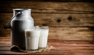 Dos vasos de leche y jarra metálica